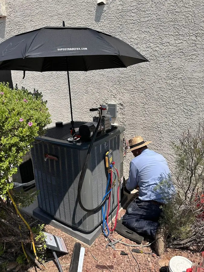 HVAC technician performing outdoor AC maintenance in Jefferson City