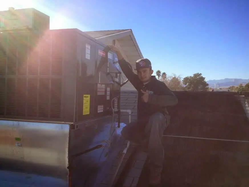 HVAC technician performing AC Tune-Up on a rooftop unit in Jefferson City